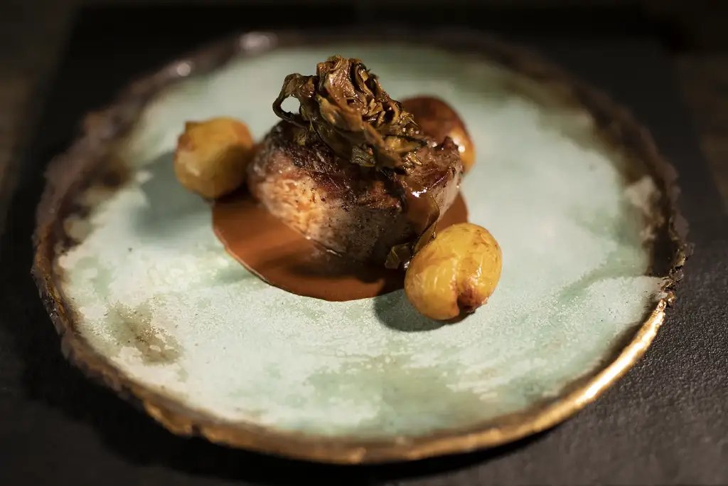 Gourmet dish served on a handcrafted plate at Pikaia Lodge
