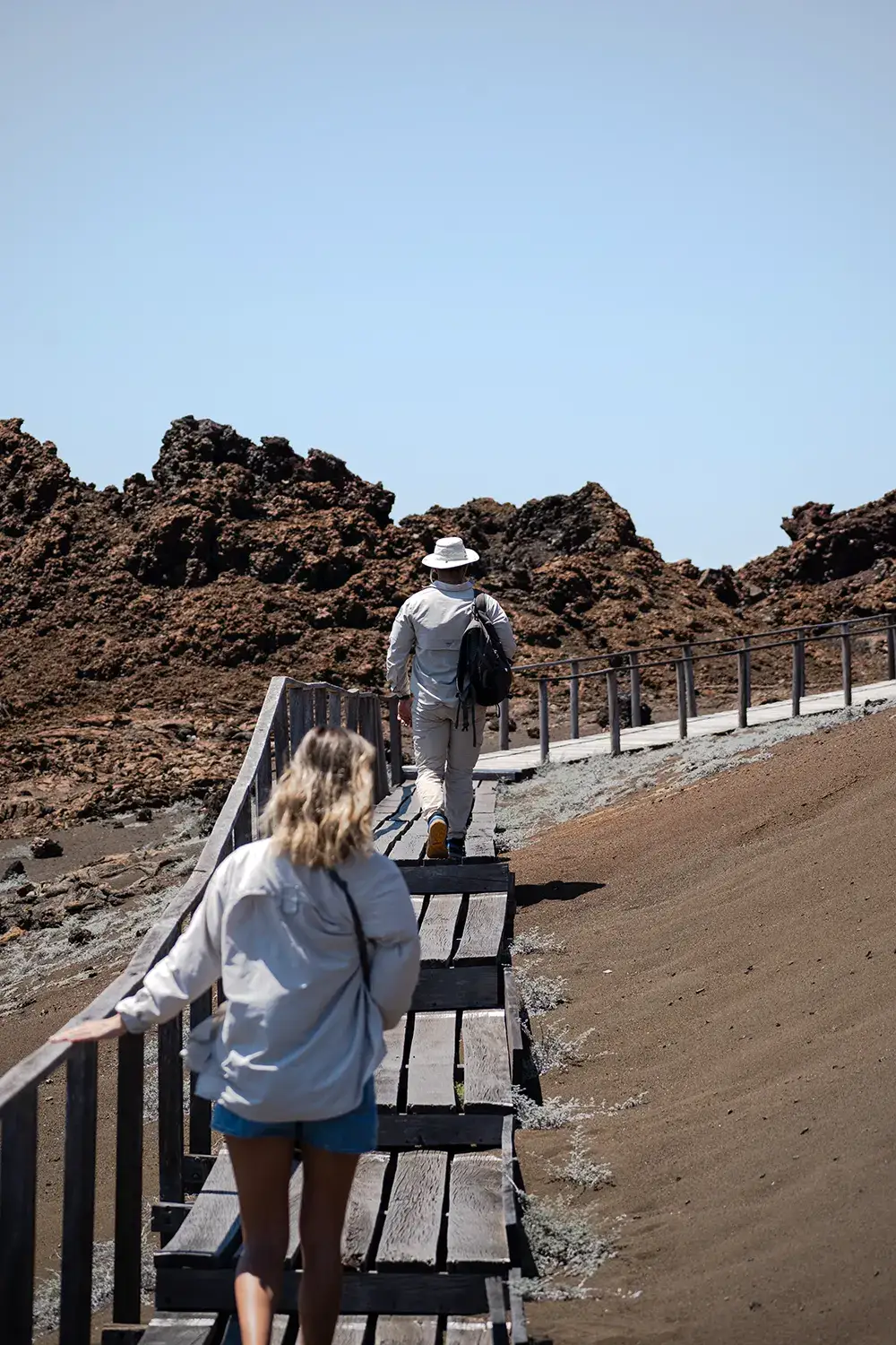 Guests hiking a volcanic boardwalk in the Galápagos