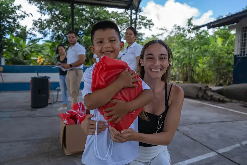 A child with a red gift bag at a community school event